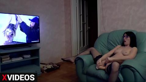 Siyah çoraplı esmer, sandalyede oturmuş bir oyuncakla kendini tatmin ediyor